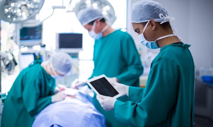 Surgeon using digital tablet in operation theater of hospital